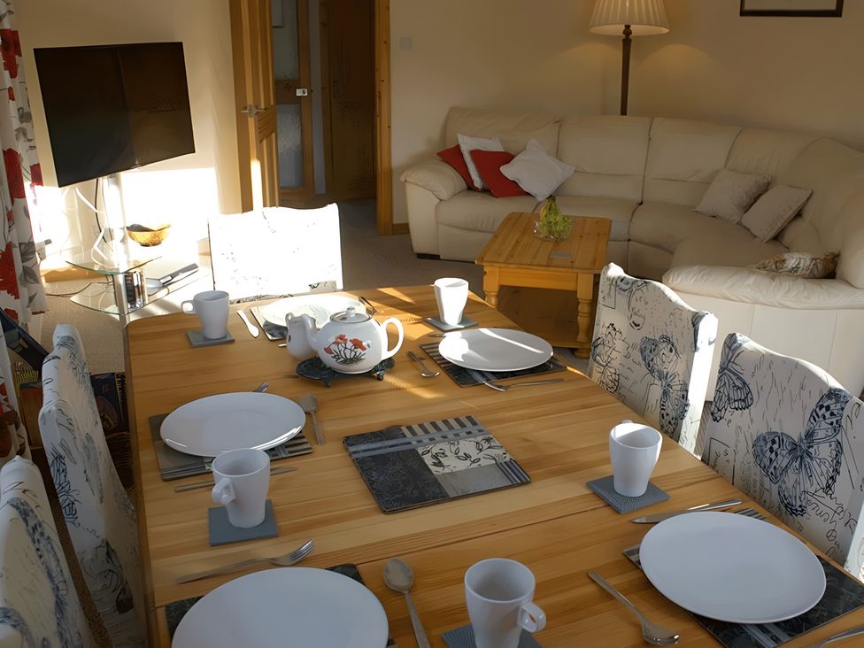 A dining room with a table set for meals at Culnacraig in Stranraer