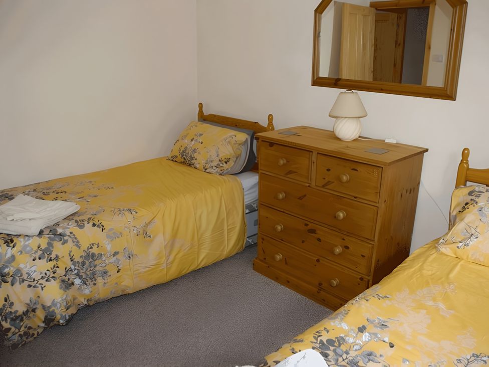 A bedroom with two beds and a chest of drawers at Culnacraig in Stranraer