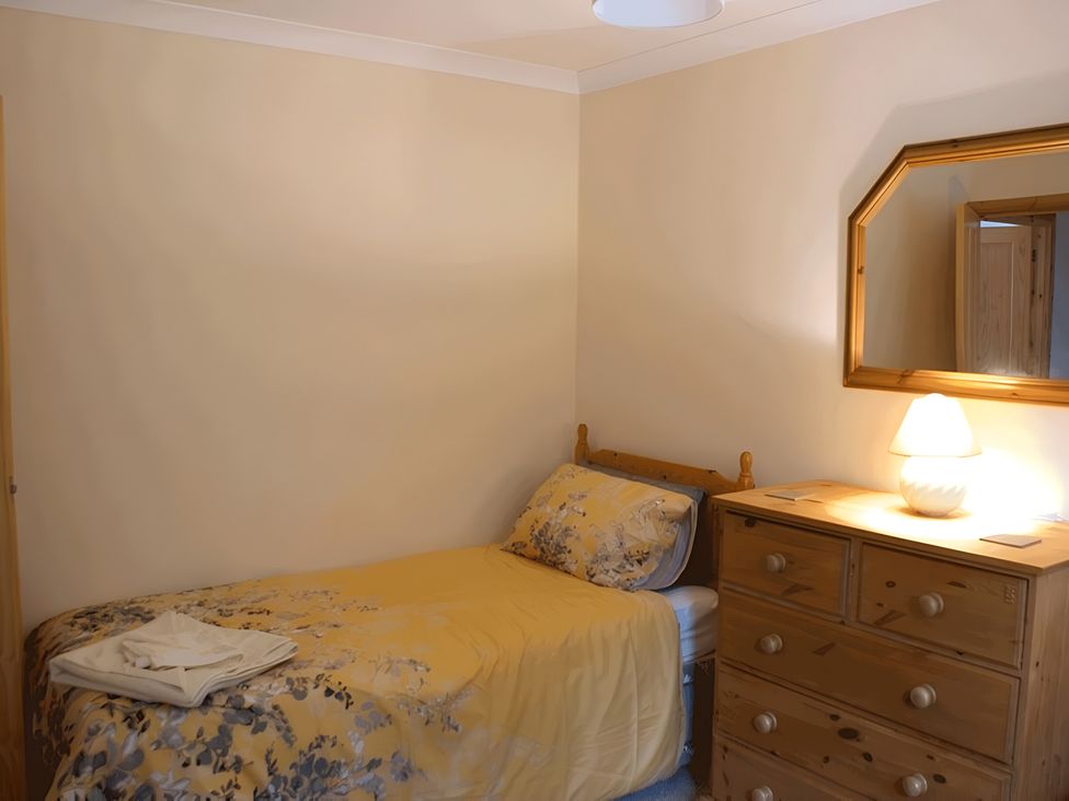 A bedroom with a single bed and wooden dresser at Culnacraig in Stranraer