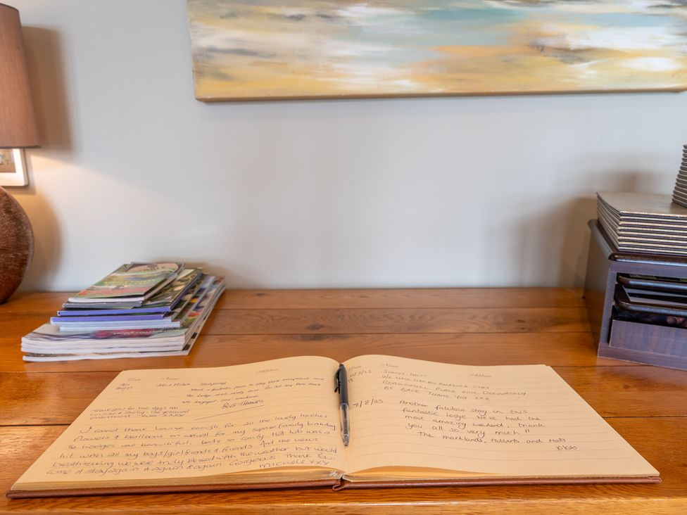 A book with handwritten notes and a pen on a table at Valley View Lodge 1 in Preston