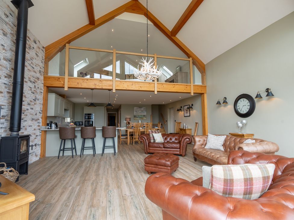 A living room with a stove and bar stools at Valley View Lodge 1 Preston