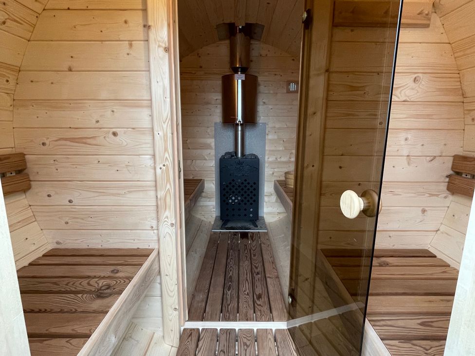 A sauna with wooden benches and a sauna heater at Valley View Lodge 1 in Preston