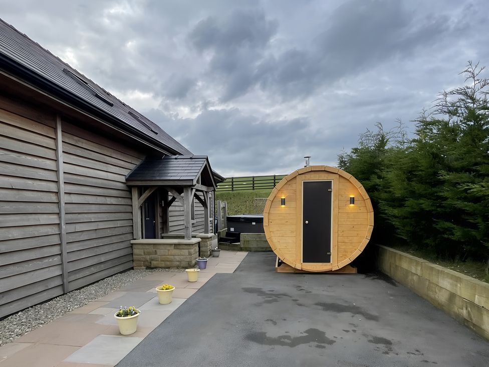 An outdoor area with a barrel sauna and planters at Pendle View in Preston