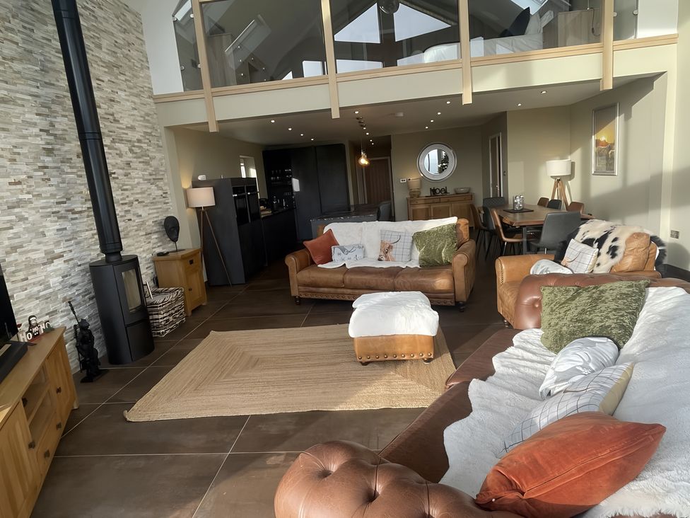 A living room with a fireplace and dining area at Pendle View Preston