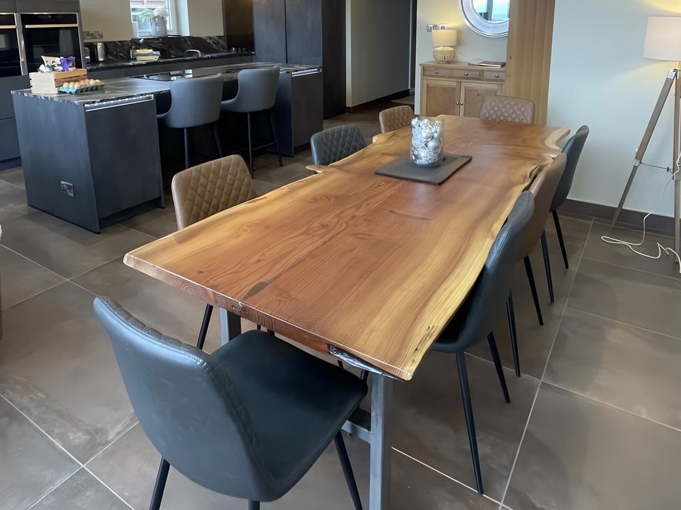 A dining room with a wooden table and chairs at Pendle View in Preston