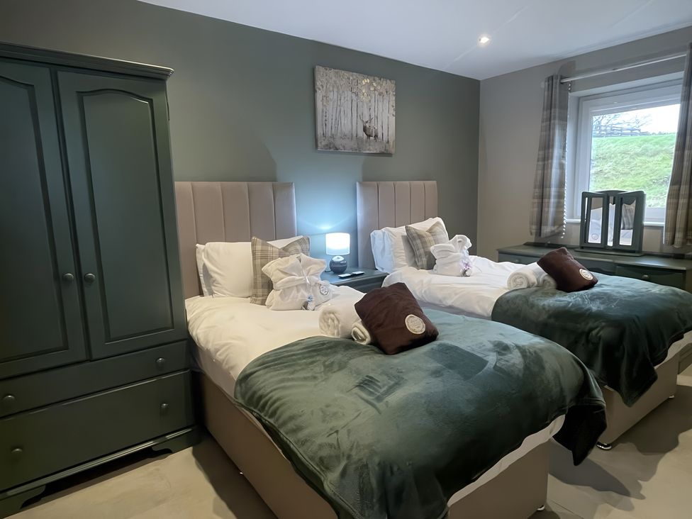 A bedroom with two beds and a wardrobe at Pendle View in Preston