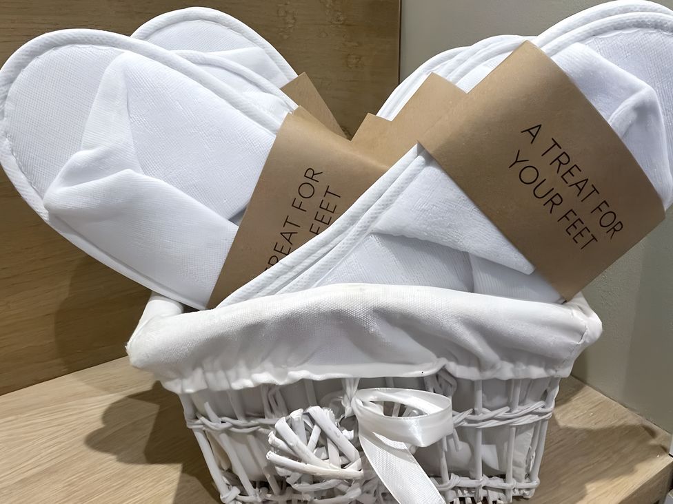 A gift basket with slippers and a tag at Pendle View Preston