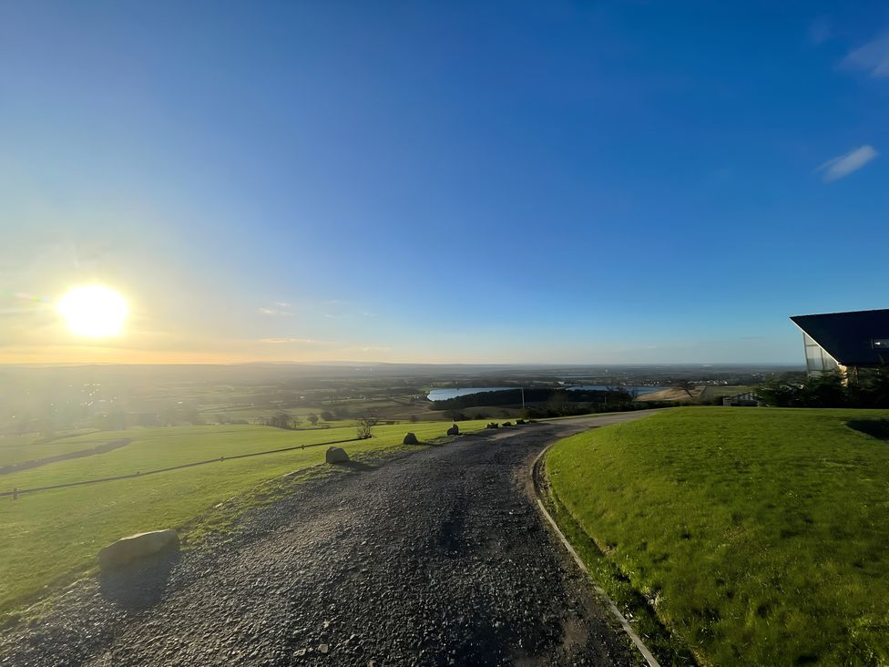 A outdoor landscape with a road leading to a hill and a waterbody at Pendle View Preston