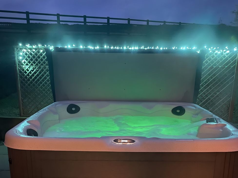 A hot tub with green water and lights at Pendle View in Preston