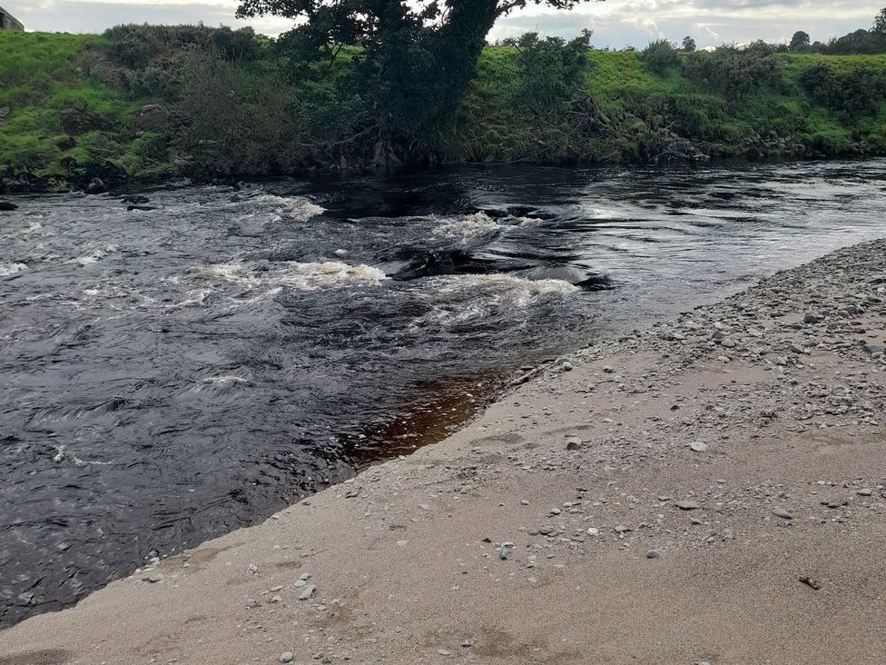 A river with sandy bank and gravel at The Farmhouse in Omagh