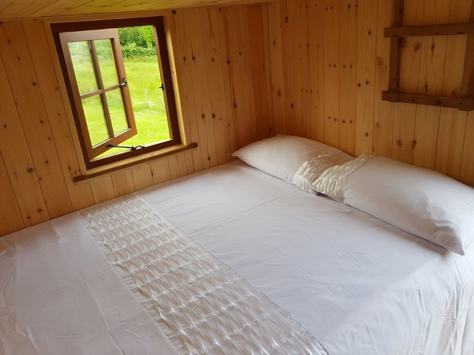A bedroom with a bed and window at Bryn Mawr Cabin in Craven Arms