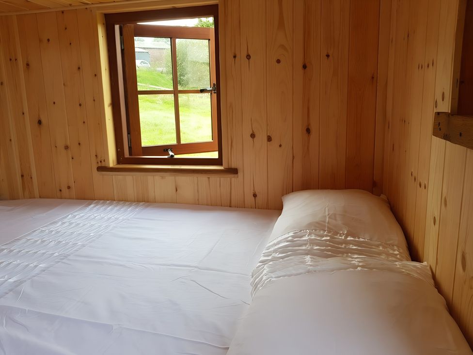 A bedroom with a bed and a window at Bryn Mawr Cabin in Craven Arms