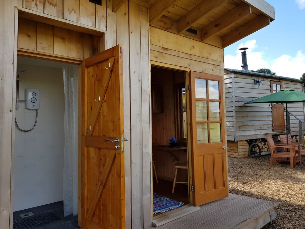 A shower and wooden doors at Bryn Mawr Cabin in Craven Arms