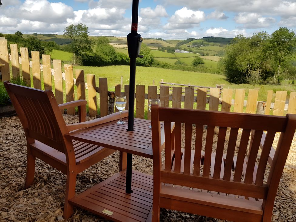 An outdoor seating area with chairs and a table at Bryn Mawr Cabin Craven Arms