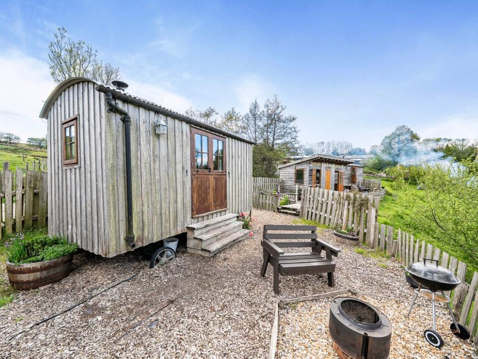 A wooden hut with steps and outdoor seating at Bryn Mawr Cabin, Clun