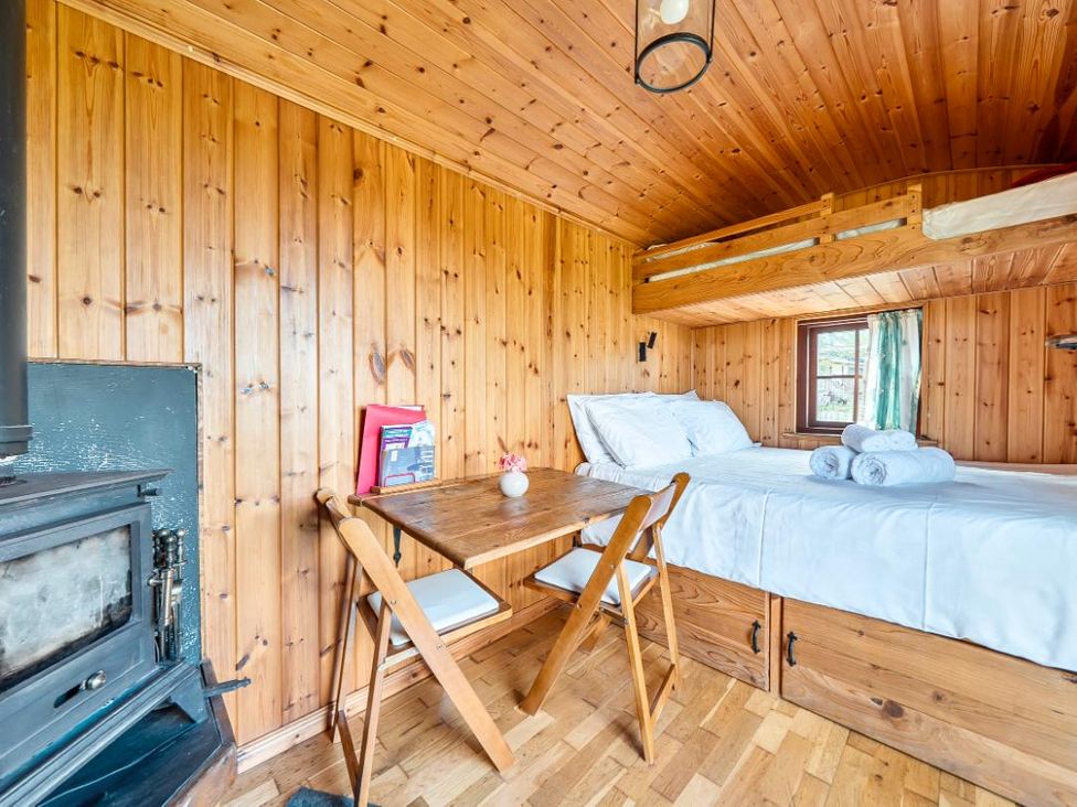 A bedroom with a bed and dining table at Bryn Mawr Cabin in Clun