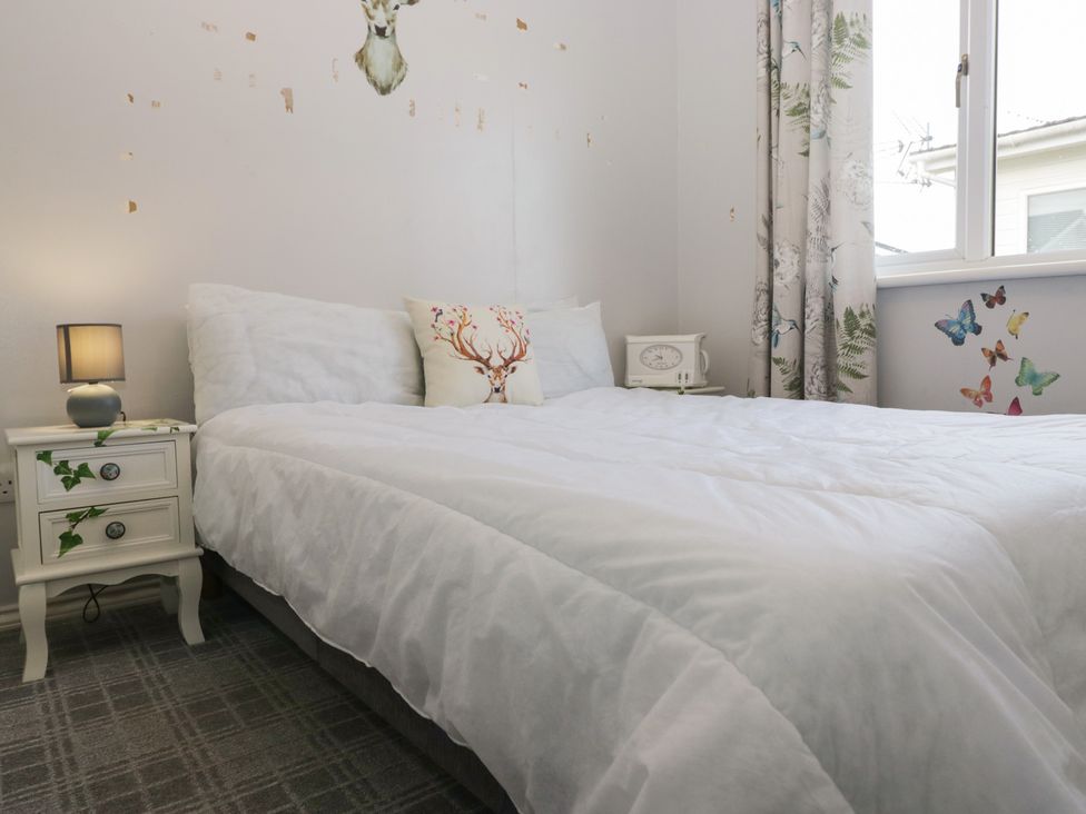 A bedroom with a bed and bedside table at Beechtree Lodge 46 in Denny