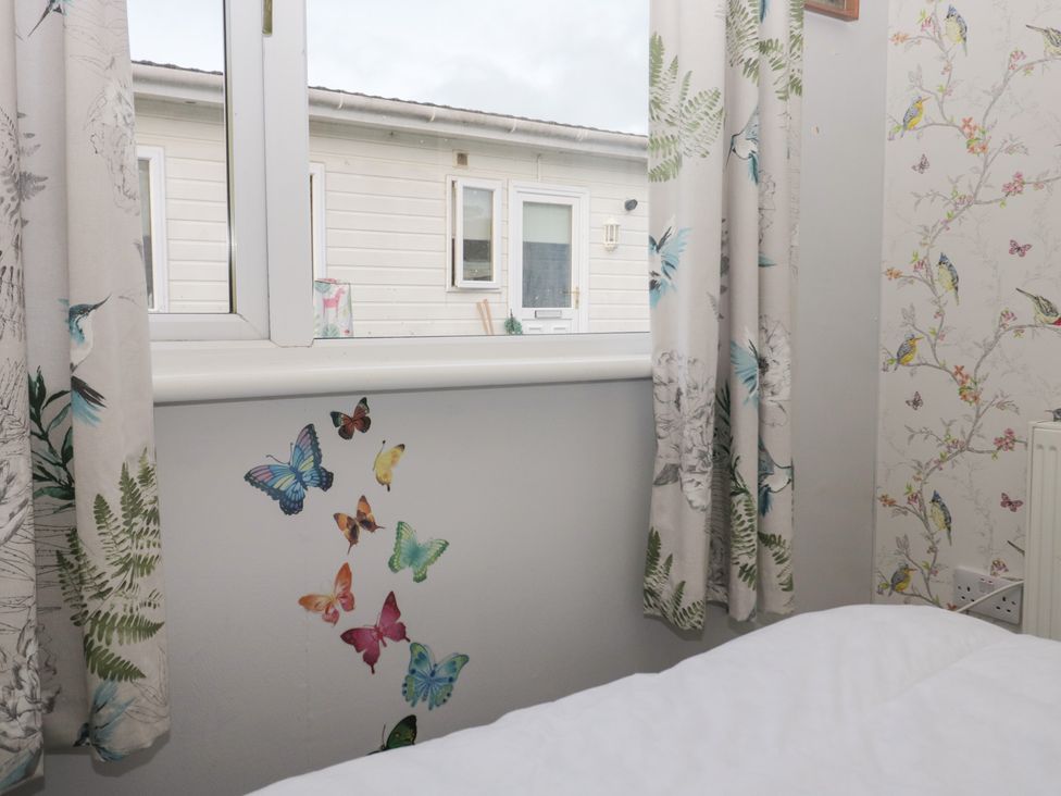 A bedroom with butterfly decals and curtains at Beechtree Lodge 46 in Denny