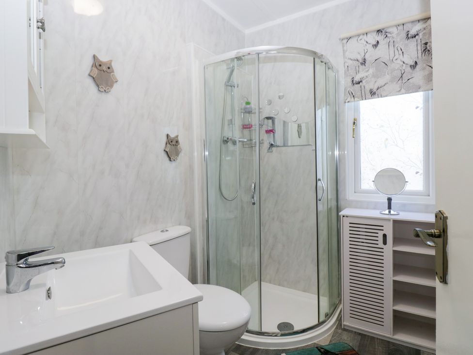A bathroom with a shower, toilet, and sink at Beechtree Lodge 46 in Denny