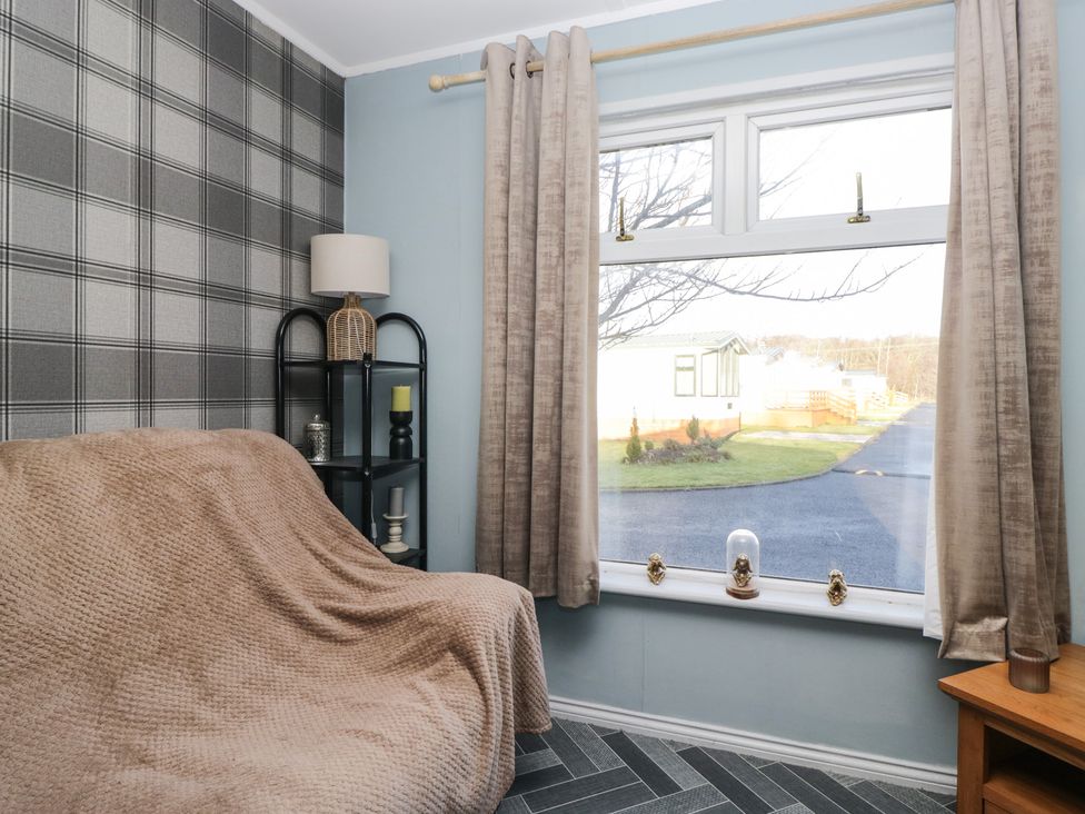 A living room with a sofa and a lamp at Beechtree Lodge 55 Denny
