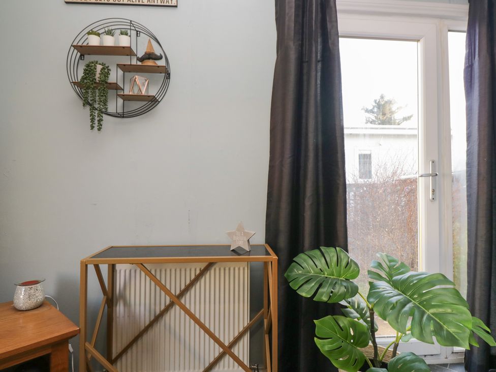 A living room with a shelf, plant, and a table at Beechtree Lodge 55 Denny