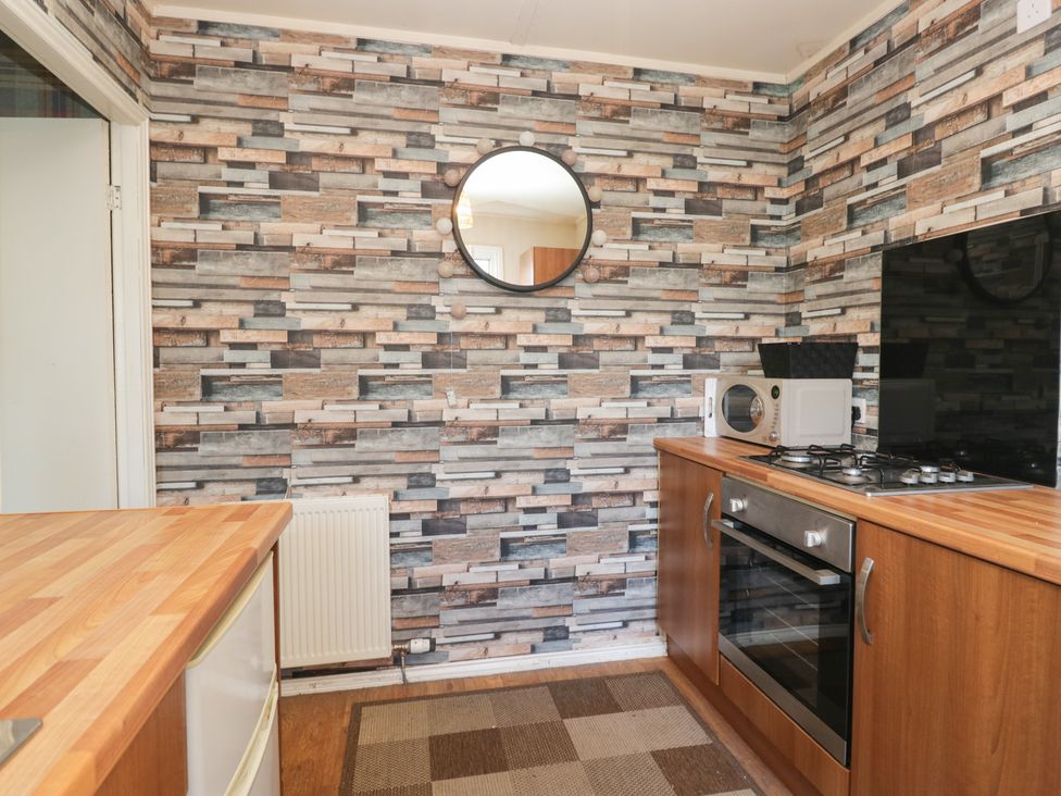 A kitchen with a microwave and gas stove at Beechtree Lodge 55 Denny
