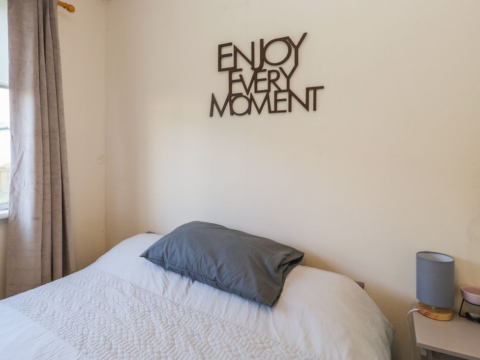 A bedroom with a bed and decorative wall art at Beechtree Lodge 55 in Denny