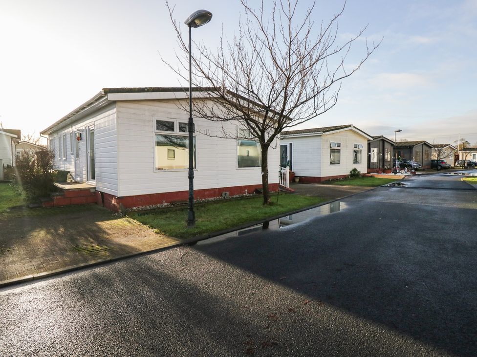 A mobile home on a street with a lamp post at Beechtree Lodge 56 Denny