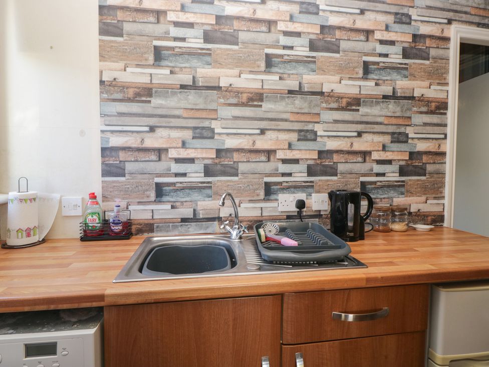 A kitchen sink with dish rack and kettle at Beechtree Lodge 56 in Denny