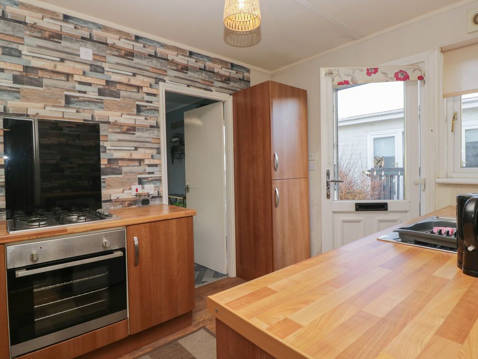 A kitchen with gas stove and refrigerator at Beechtree Lodge 56 Denny