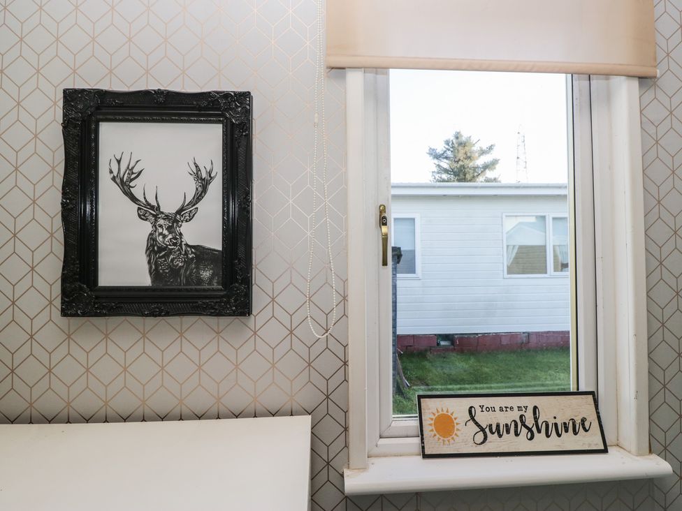 A framed picture and sign on a wall with a window at Beechtree Lodge 56, Denny