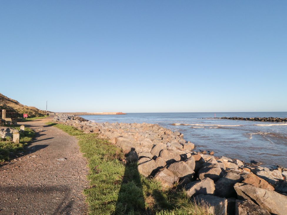 A coastal pathway along rocks next to the ocean at Isla’s Sea Forge Saltburn-by-the-Sea