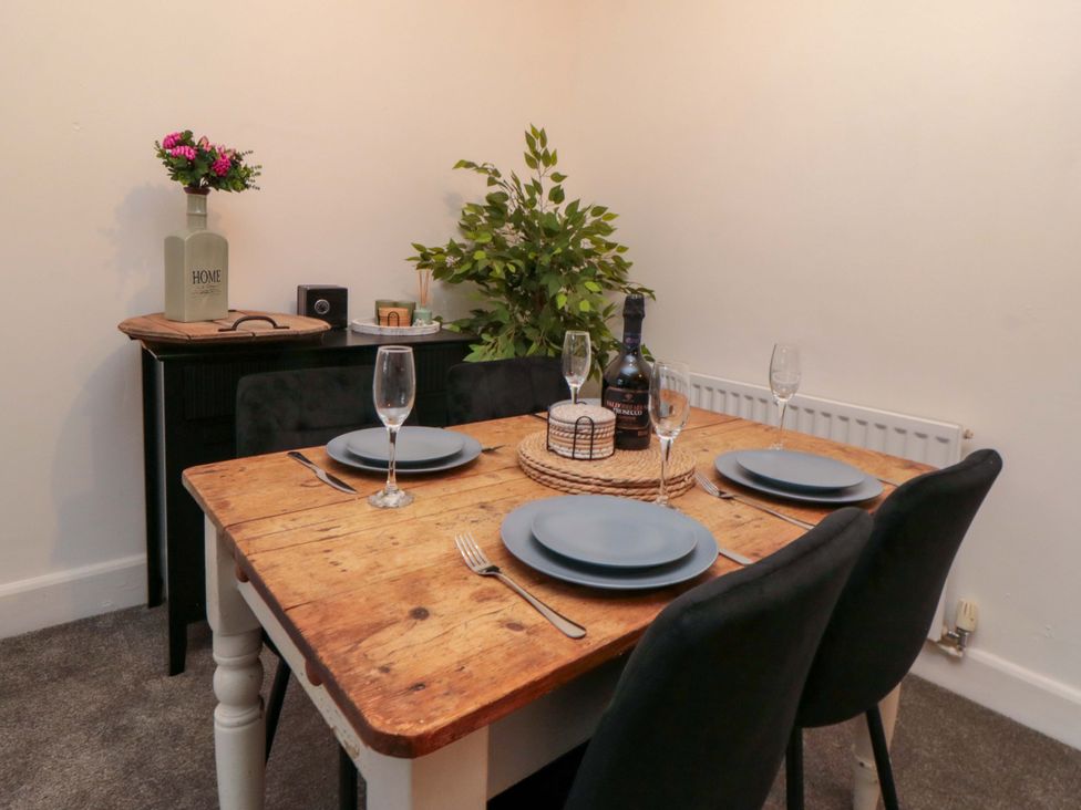 A dining room with a wooden table set for four at Isla’s Sea Forge in Saltburn-by-the-Sea