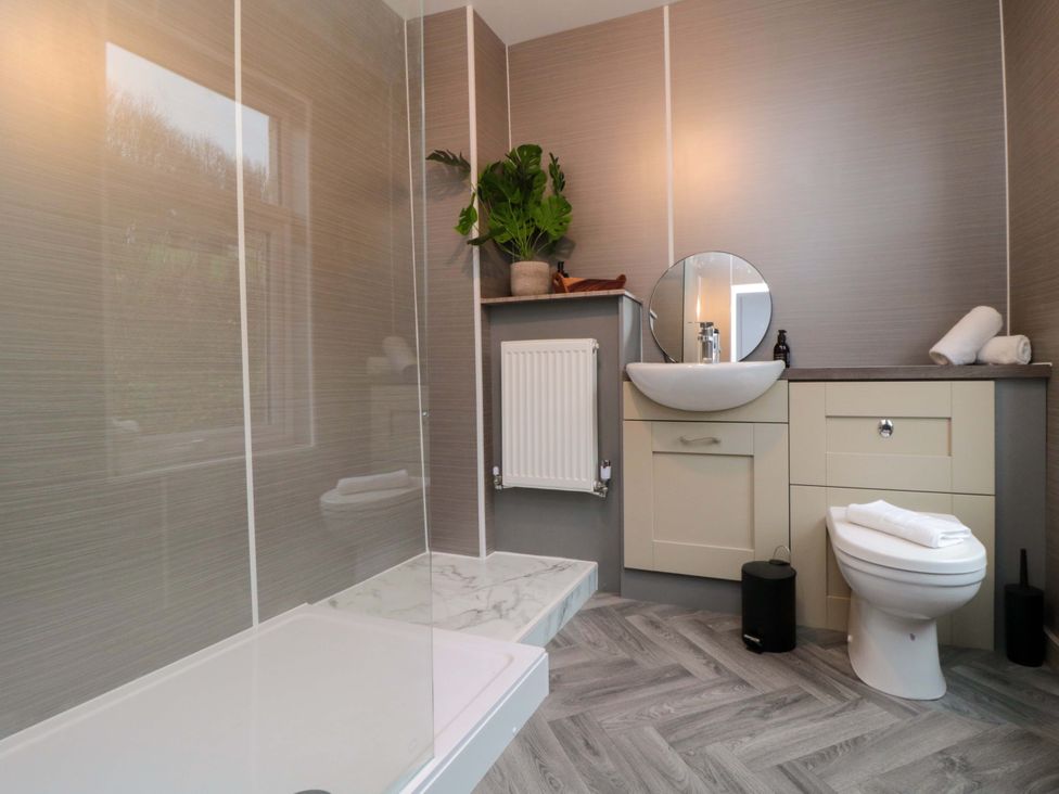 A bathroom with a sink, toilet, and bath at Isla’s Sea Forge, Saltburn-by-the-Sea
