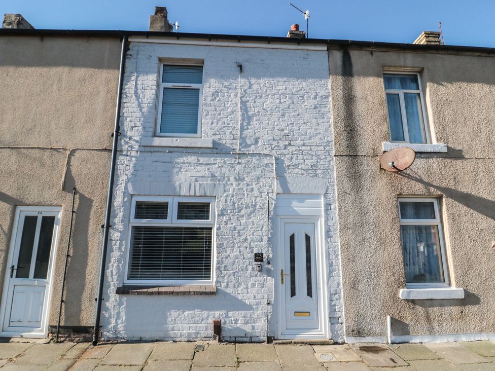 A house front with white painted wall and satellite dish at Isla’s Sea Forge in Skinningrove