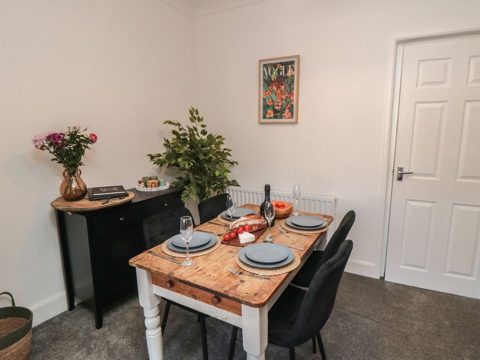 A dining room with a wooden table set for four at Isla’s Sea Forge in Skinningrove