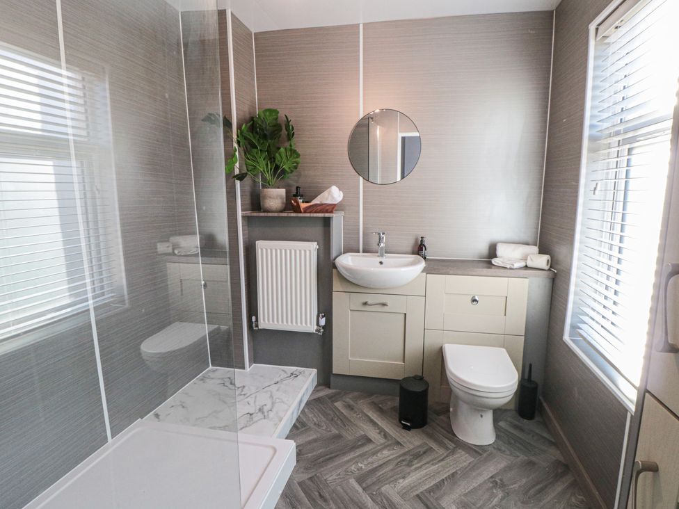 A bathroom with a shower, sink, and toilet at Isla’s Sea Forge in Skinningrove