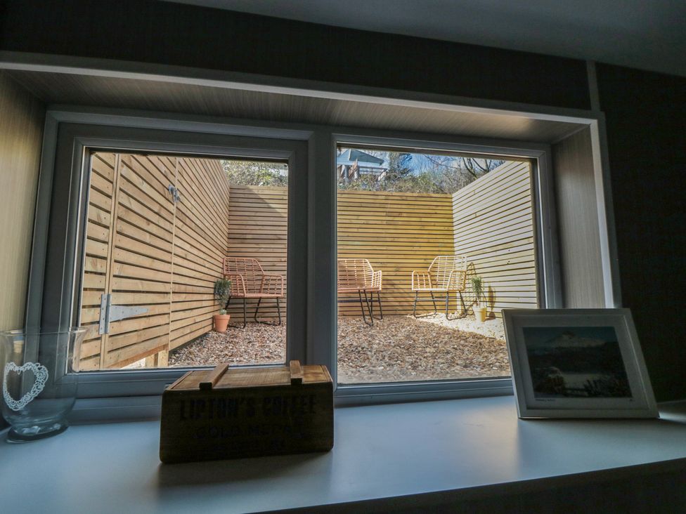 A view from a window with chairs and a planter at Isla’s Sea Forge Skinningrove
