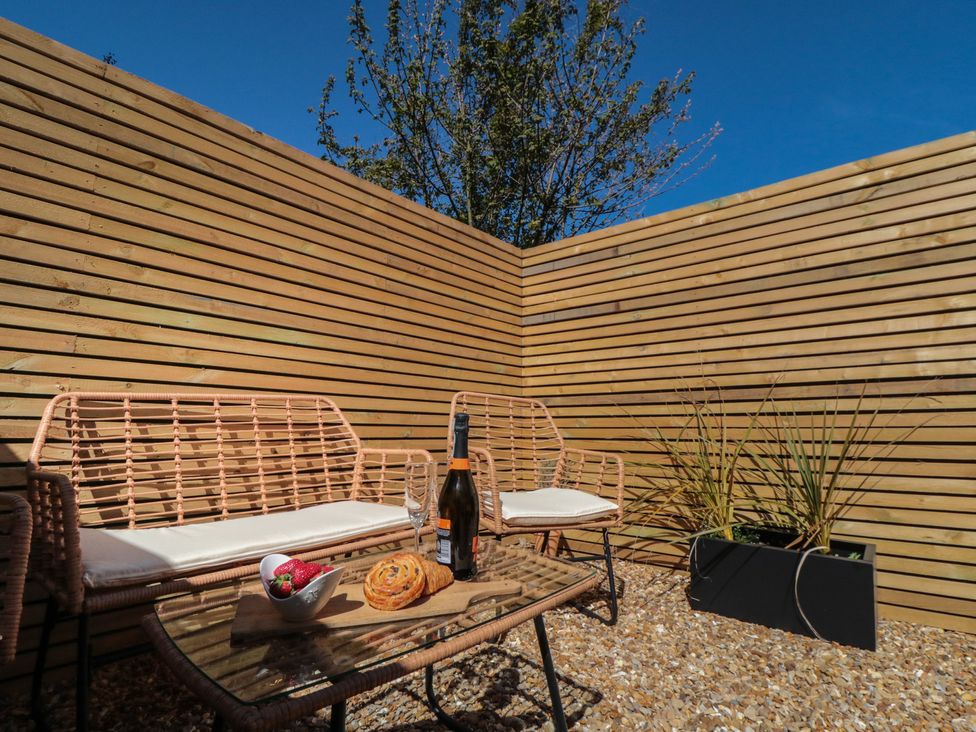 An outdoor seating area with chairs and a table at Isla’s Sea Forge in Skinningrove