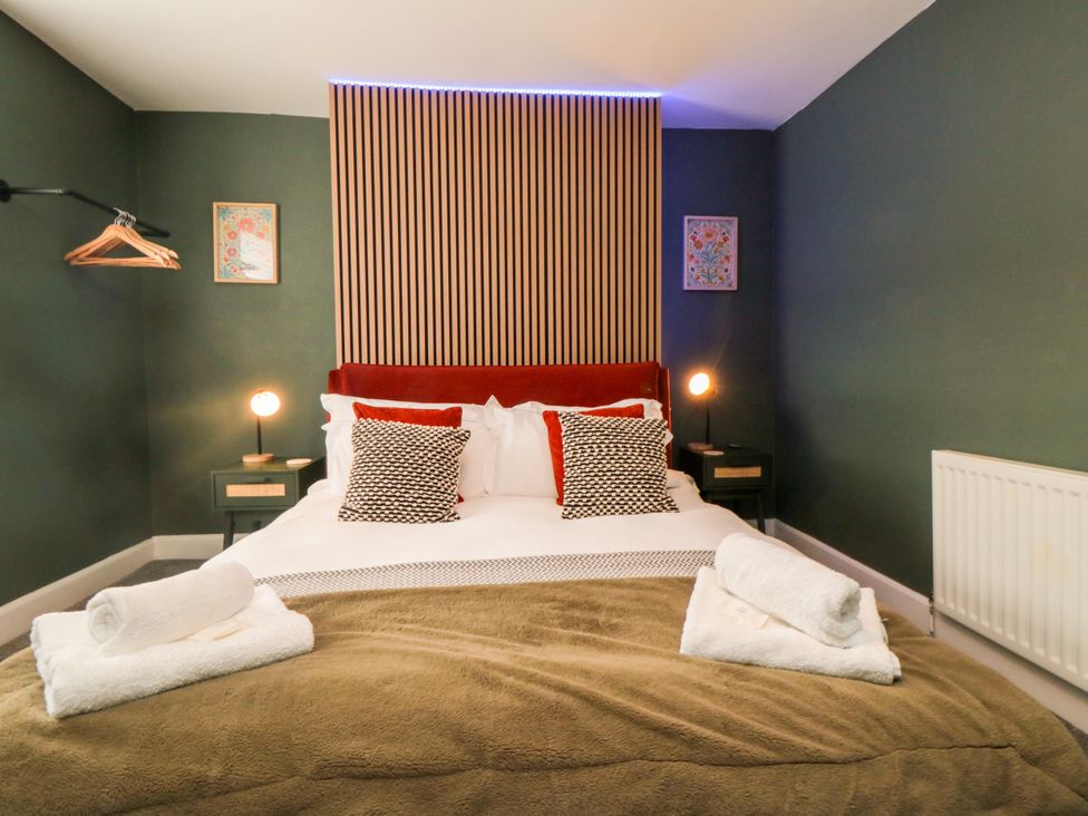 A bedroom with a bed and nightstands at Isla’s Sea Forge in Skinningrove