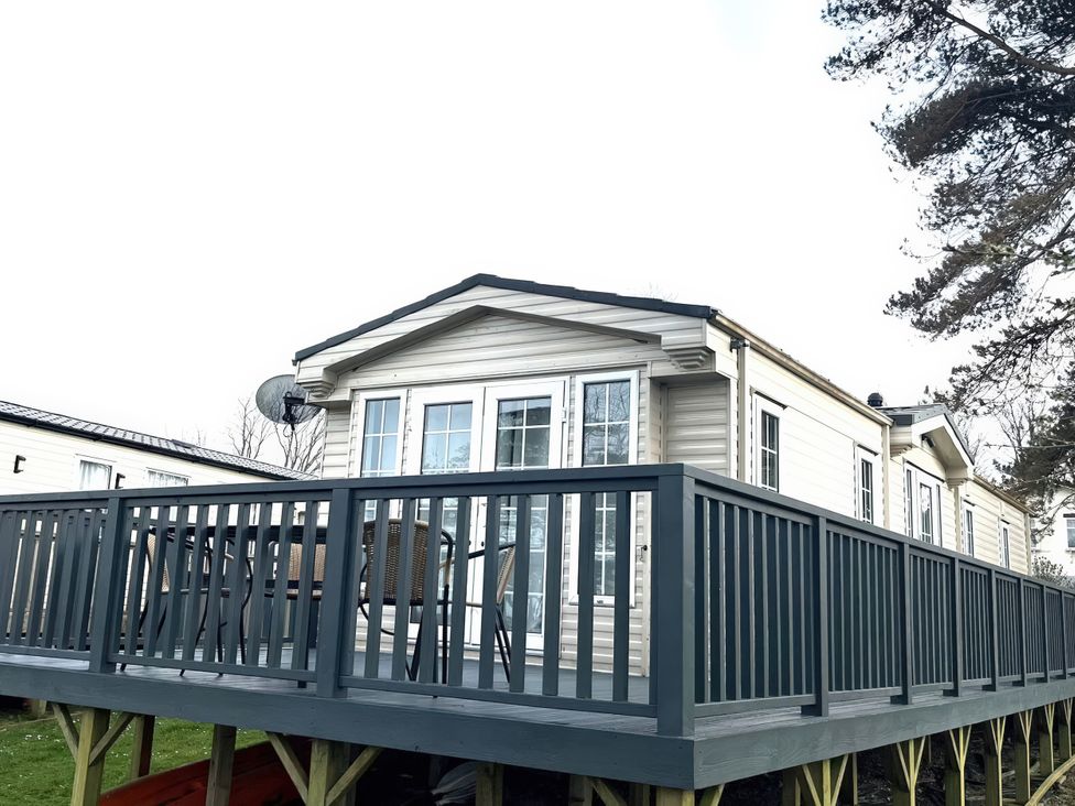 A caravan with decking and table at Caravan 38 Newport