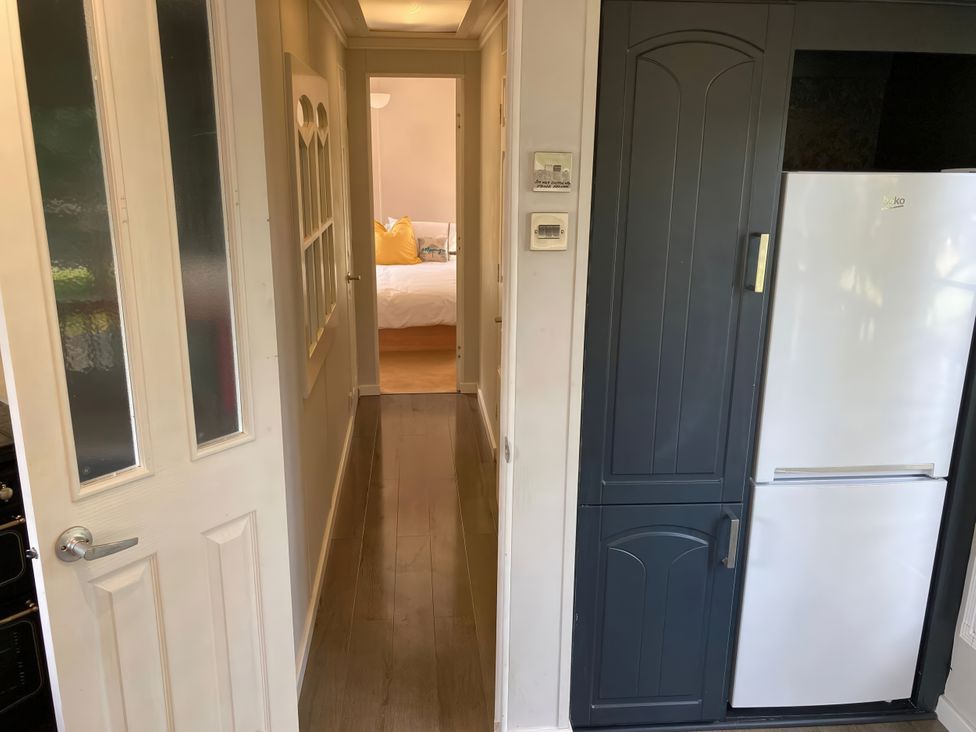 A kitchen with a refrigerator and hallway access at Caravan 38 Newport