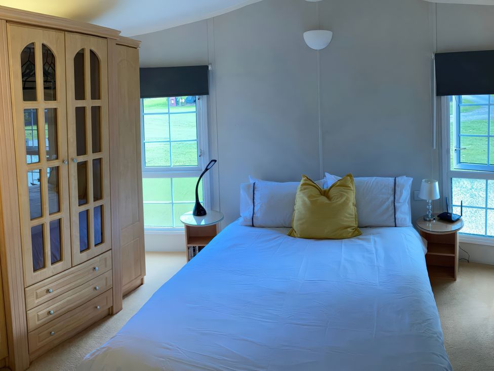 A bedroom with a bed and wardrobe at Caravan 38 in Newport