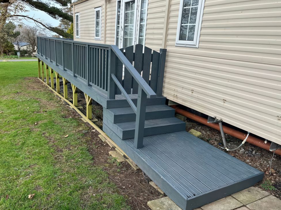 A wooden deck with steps in an outdoor area at Caravan 38 Newport