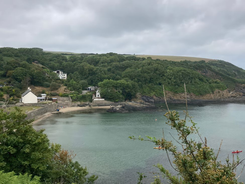 A scenic view of a beach and water surrounded by greenery and houses at Caravan 38 Newport