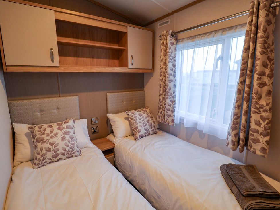 A bedroom with two twin beds and a window at Paws By The Sea Norwich