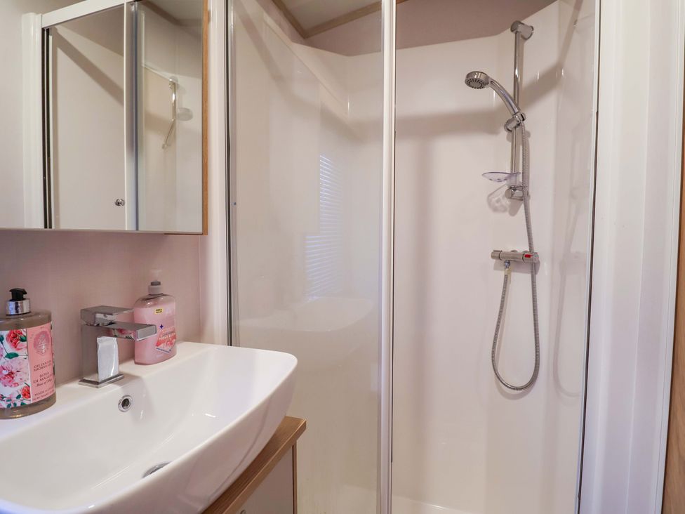 A bathroom with a sink and shower at Paws By The Sea in Norwich