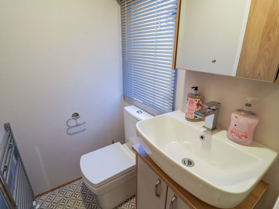 A bathroom with a sink and toilet at Paws By The Sea Norwich