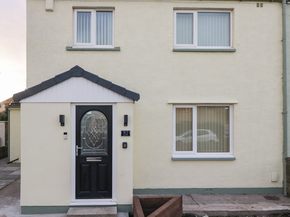 A house exterior with a black door and windows at Mables in Wigton