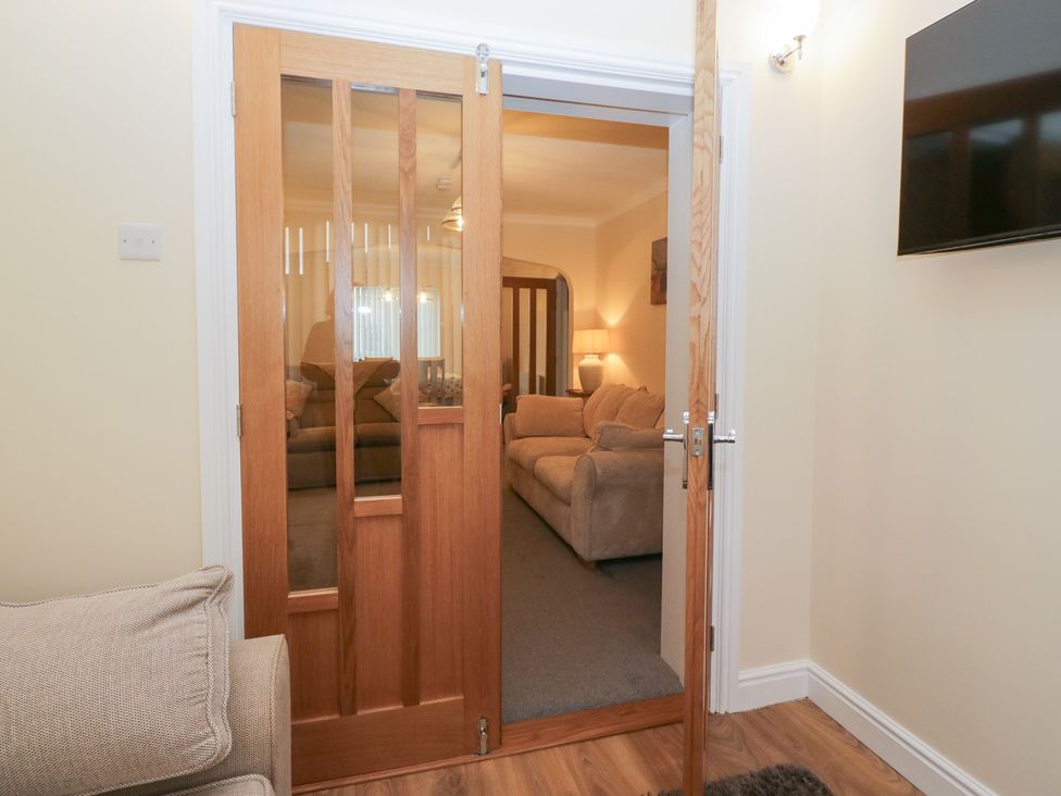 A living room with a doorway and sofa at Mables in Wigton